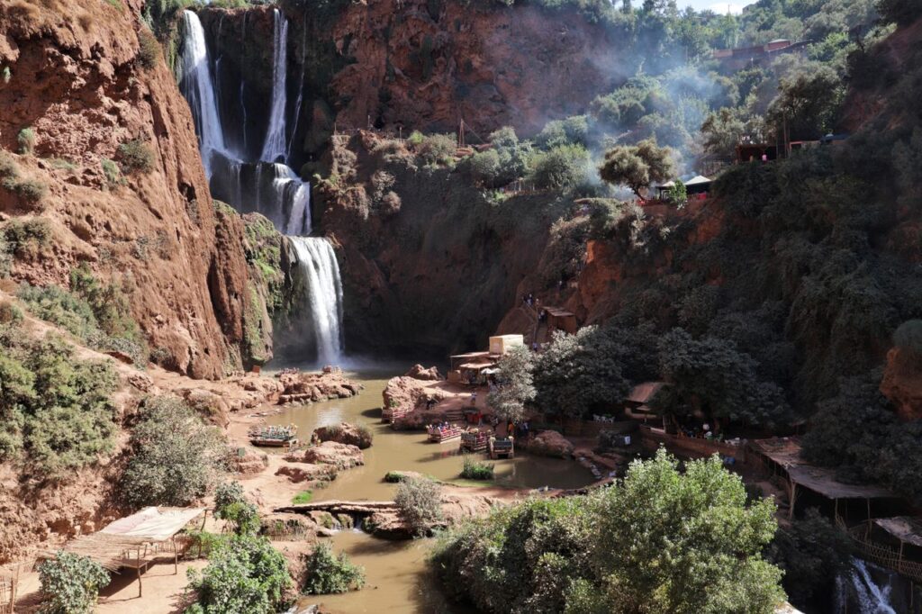 Stunning waterfall cascading through rocky cliffs surrounded by vibrant greenery in a tranquil canyon.