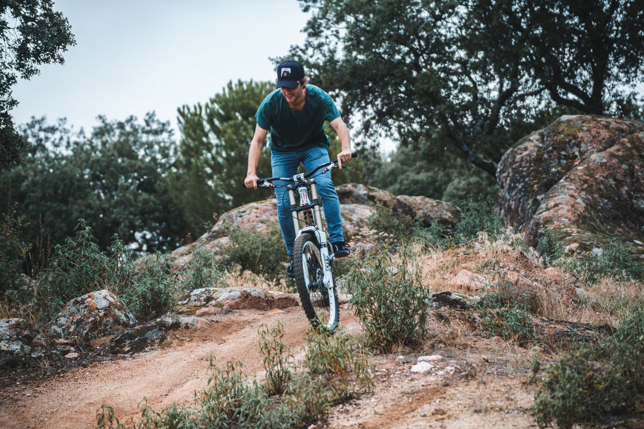 Man enjoying a thrilling mountain bike ride on a rugged trail in the outdoors.